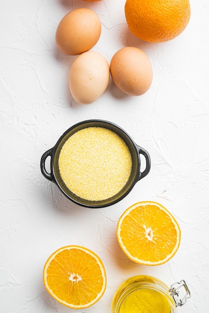 Hausgemachte orangefarbene Kuchenzutaten, mit Eiern und Honig, auf weißem Steintischhintergrund, Draufsicht flach