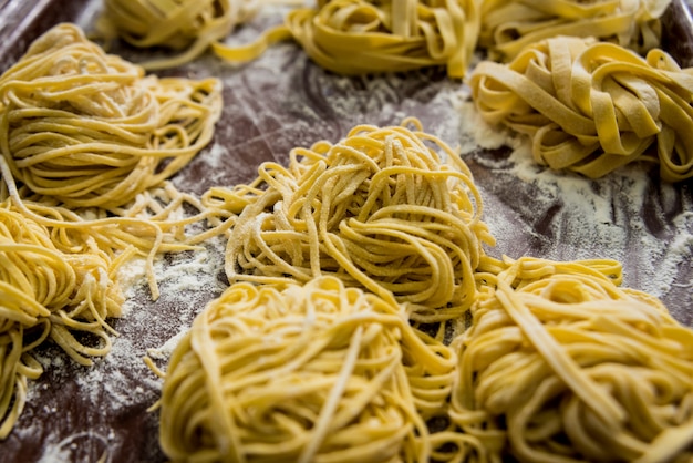 Hausgemachte Pasta auf einem Holztisch. Italienische Küche. Restaurant.