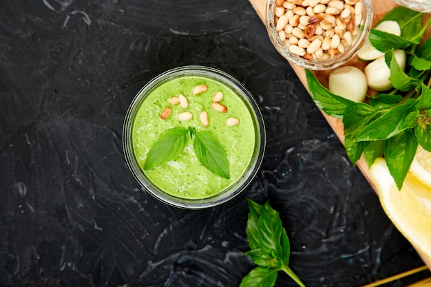 Hausgemachte Pesto-Sauce im Glas mit Zutaten.