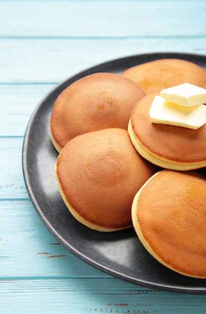 Hausgemachte Pfannkuchen mit Butter im Teller auf dunklem Teller