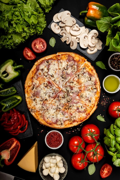 Hausgemachte Pizza bereit zu essen mit rohen Zutaten. Draufsicht.