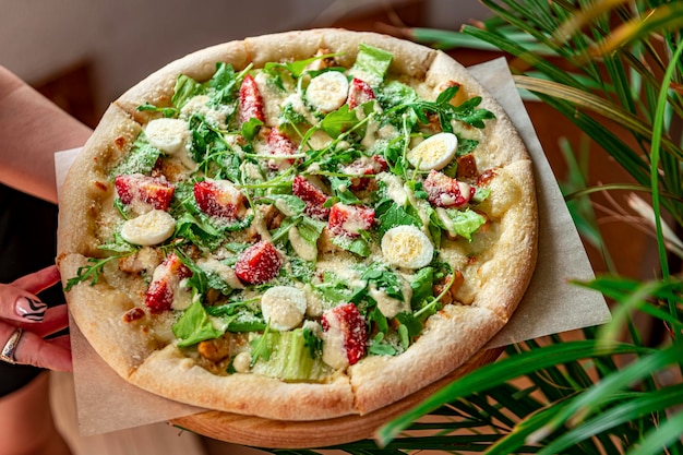 Hausgemachte Pizza mit Caesar-Salat eine interessante Portion Salat mit Hühnerfleisch