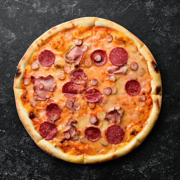 Hausgemachte Pizza mit Speck und Salami auf dem Tisch Rustikale Ansicht von oben