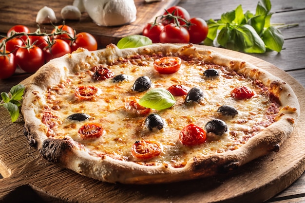 Hausgemachte Pizza mit Tomaten Mozzarella Käse Oliven und Basilikum