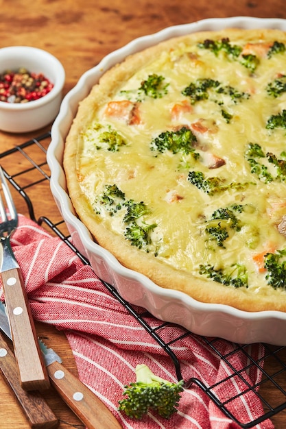 Hausgemachte Quiche mit rotem Fisch, Lachs, Brokkoli und Käse auf Holzhintergrund