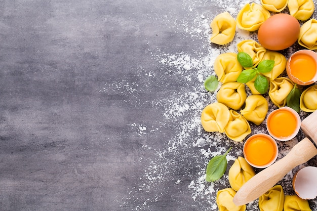 Hausgemachte rohe italienische Tortellini und Basilikumblätter.