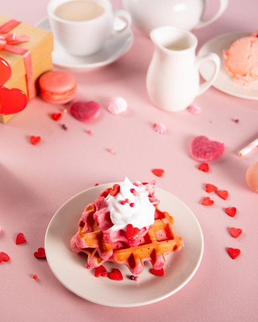 Hausgemachte rosa Waffeln mit Schlagsahne Valentinstag Muttertag Konzept Leckeres Frühstück