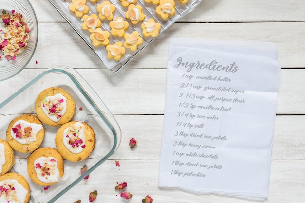 Hausgemachte Rose Shortbread-Kekse auf weißer Holztischplatte mit Rezept