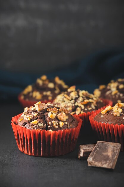Hausgemachte Schokoladenmuffins oder Cupcakes mit Nüssen auf dunklem Hintergrund