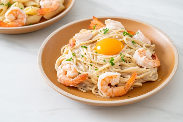 Hausgemachte Spaghetti mit weißer Sahnesauce mit Garnelen und Eigelb