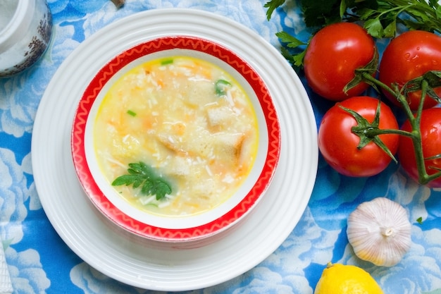 Hausgemachte suppe in einem teller, auf einem tisch mit gemüse und gewürzen