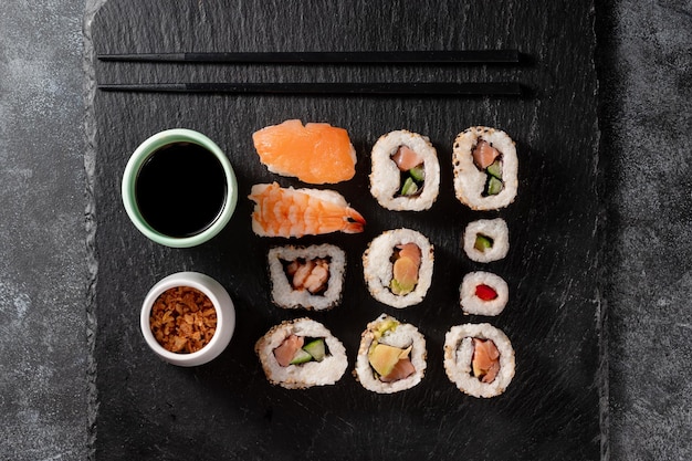 Hausgemachte Sushi-Rollen mit Lachs-Garnelen-Avocado, serviert mit Sojasauce und Ingwer