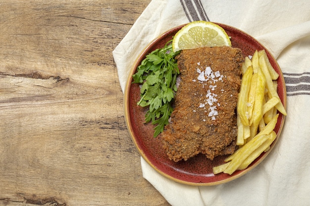 Hausgemachte traditionelle Mailänder Kalbsschnitzel mit Pommes Frites, Salat, Mayonnaise-Sauce