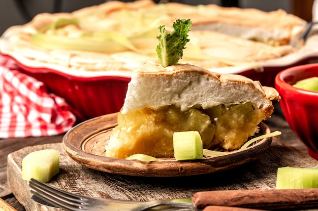 Hausgemachte traditionelle Rhabarberpastete aus Bio mit Baiser. auf rustikalem Holztisch. veganes Essen