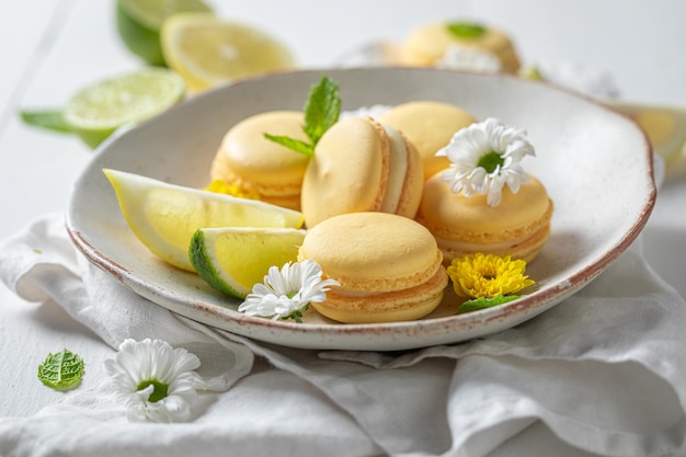 Hausgemachte und saure Zitronenmakronen mit Frühlingsblumen auf dem Teller