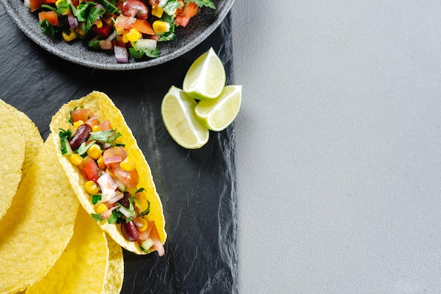 Hausgemachte vegane Tacos mit schwarzen Bohnen, Mais und Gemüse das Konzept des sauberen Essens auf pflanzlicher Basis