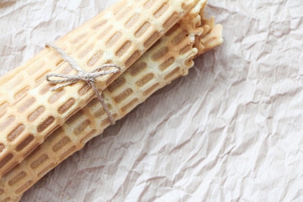 Hausgemachte Waffelrollen mit Jute auf Backpapier gebunden