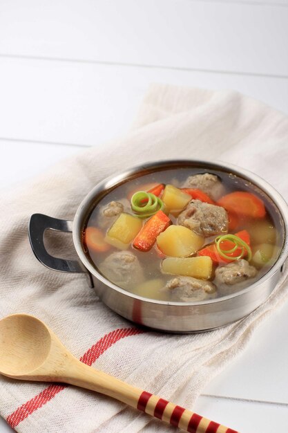 Hausgemachte warme Gemüse-Fleischbällchensuppe mit Karotten und Kartoffeln, serviert auf einer Edelstahlschüssel