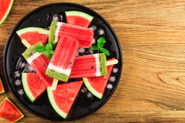 Hausgemachte wassermelone eis am stiel auf einem teller.