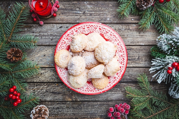 Hausgemachte Weihnachtsplätzchen in einem roten Teller mit festlicher Dekoration