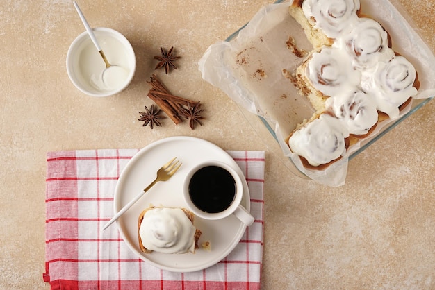 Hausgemachte Zimtschnecke und Kaffee auf Draufsicht des braunen Hintergrundes