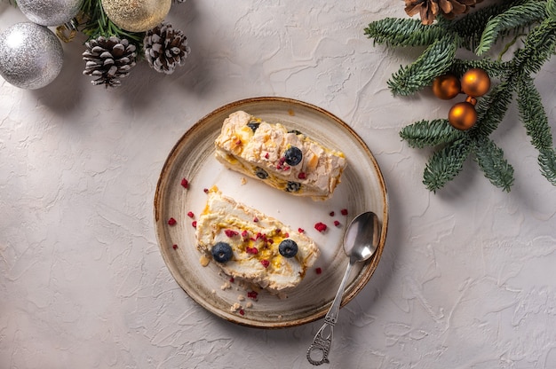 Hausgemachte zwei Stücke Baiser Rollkuchen mit Sahne, Beeren und Mandeln auf Teller