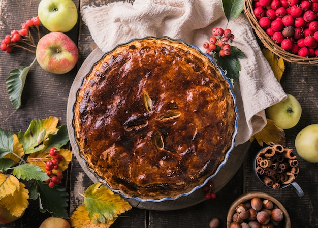 Hausgemachter Apfelkuchen mit Früchten und Herbstlaub