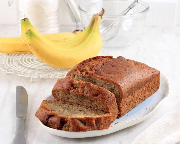 Hausgemachter Bananenkuchen oder Bananenbrot auf weißem Tisch geschnitten