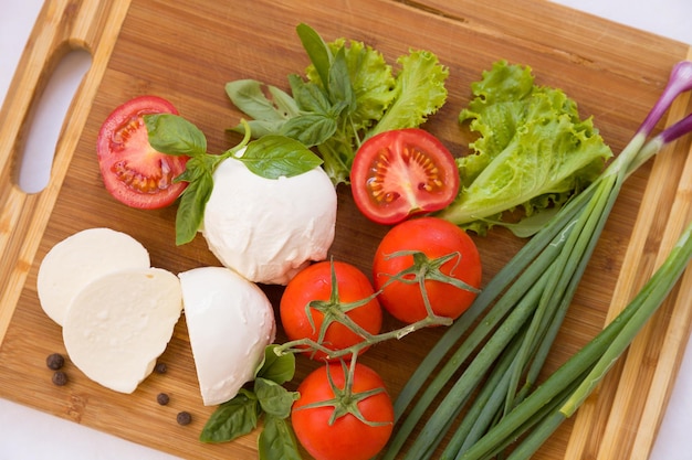 Hausgemachter Bio-Mozzarella-Käse mit Tomaten und Basilikum und Zwiebeln