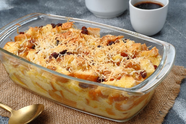 Hausgemachter Brot-Butter-Pudding mit Rosinen und geriebenem Käse als Topping