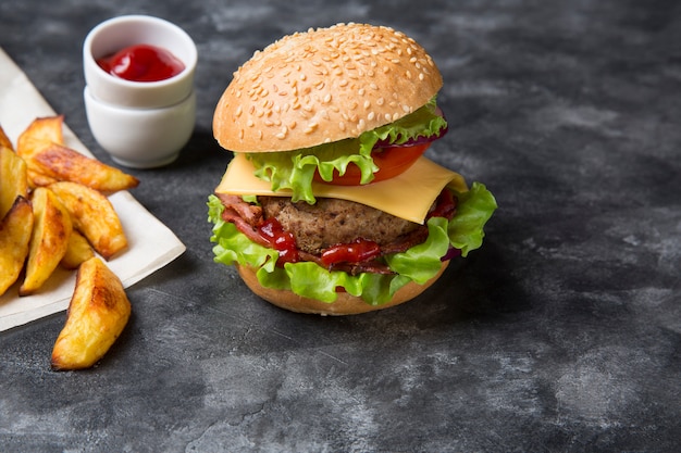 Hausgemachter Burger mit gegrillten Kartoffeln, serviert mit Ketchup-Sauce. Burger mit Rinderfilet.