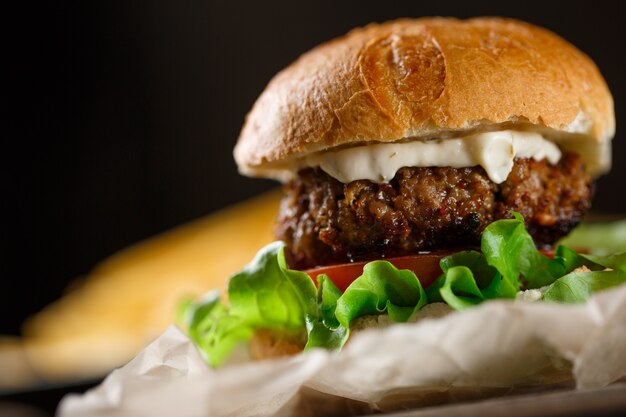 Hausgemachter Burger mit Pommes Frites auf Holztisch