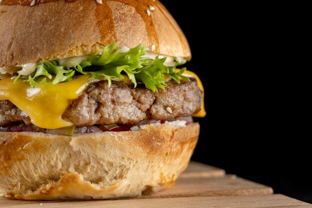 Hausgemachter Burger mit Preiselbeer-Marmelade-Rindfleisch-Patty und eingelegten Gurken auf einem Holzbrett