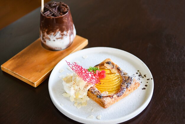 Hausgemachter Dessert köstlicher Kuchen mit Pfirsichen und Puderzucker und Kakaogetränk