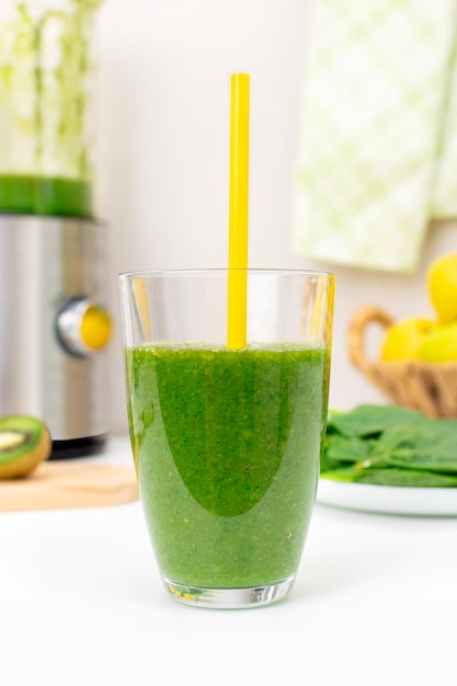 Hausgemachter detox grüner spinat-smoothie im glas mit trinkhalm. gesundes essen und abnehmen