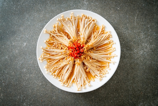 Foto hausgemachter gedämpfter goldnadelpilz oder enokitake mit sojasauce, chili und knoblauch