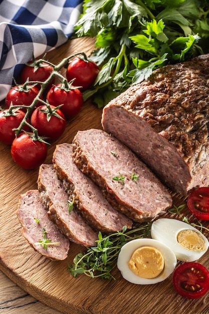 Hausgemachter Hackbraten mit Eiern, Tomaten, Selleriekräutern und Thymian.