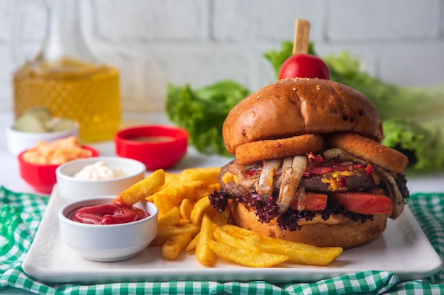 Hausgemachter Hamburger mit Pommes frites. Es sieht köstlich aus, zubereitet mit Zwiebeln, Hamburger-Patties, Cheddar-Käse und Schinken.