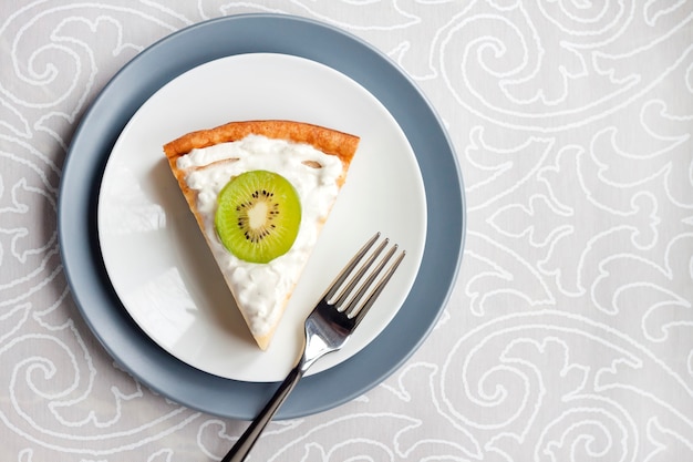 Hausgemachter Hüttenkäsekuchen mit Kiwi und Sahne