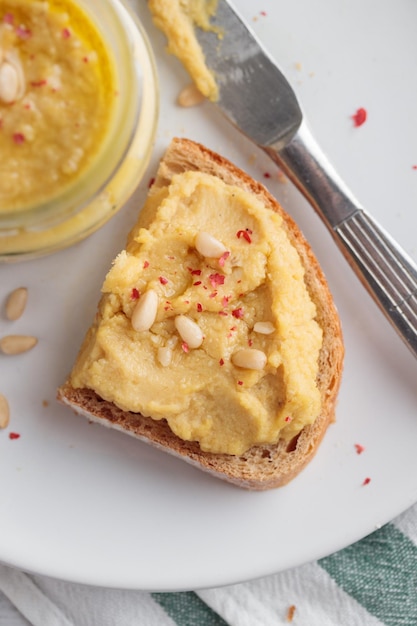 Hausgemachter Hummus mit Pinienkernen und Brot