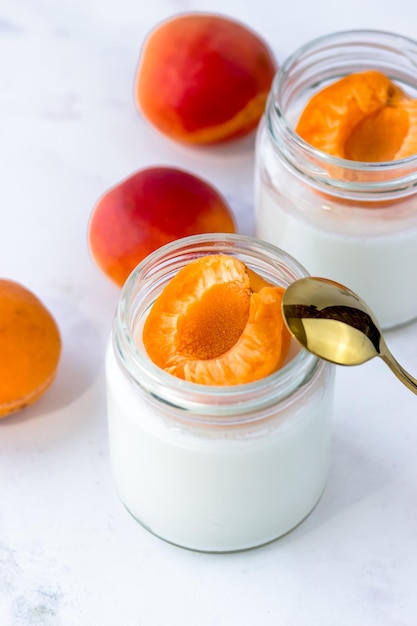 Hausgemachter Joghurt mit saftigen Aprikosen Joghurt auf einem weißen Tisch Draufsicht