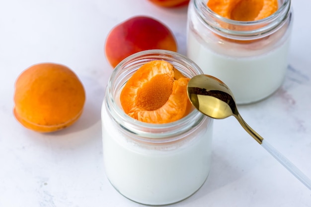 Foto hausgemachter joghurt mit saftigen aprikosen joghurt auf einem weißen tisch