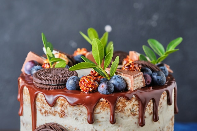 Hausgemachter Kuchen für den Urlaub mit Frischkäsecreme, dekoriert mit Schokoladenkeksen und Beeren.