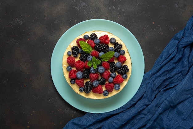 Hausgemachter Kuchen mit frischen Beeren im Dunkeln.