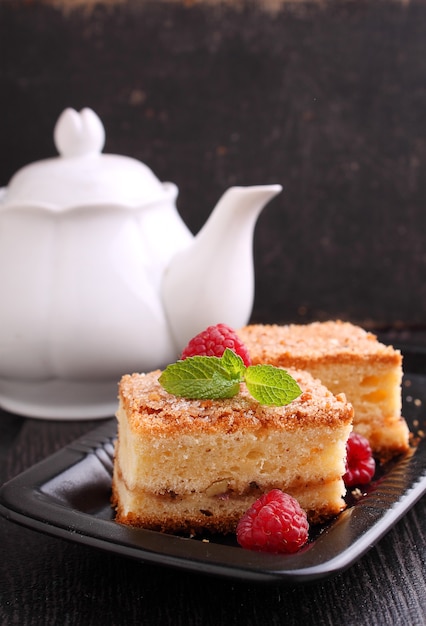 Foto hausgemachter kuchen mit walnüssen, zimt und zucker, dekoriert mit minze auf dunklem hintergrund