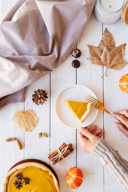 Hausgemachter Kürbiskuchen mit Herbstlaub auf rustikalem Hintergrund,