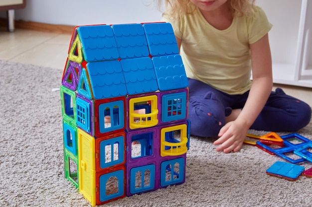 Foto hausgemachter magnetischer konstruktor gesichtsloser kinderhintergrund, der hauskonstrukteur baut