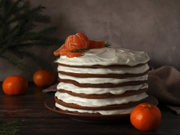 Hausgemachter mehrschichtiger Schokoladenkuchen mit weißer Sahne und Mandarinen