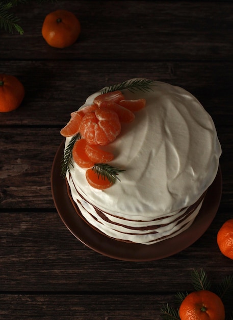 Hausgemachter mehrschichtiger Schokoladenkuchen mit weißer Sahne und Mandarinen