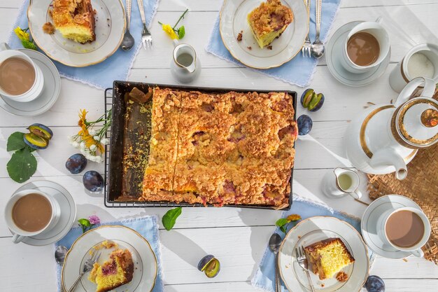 Hausgemachter Nachtisch mit Pflaumenkuchen und Kaffee im Garten